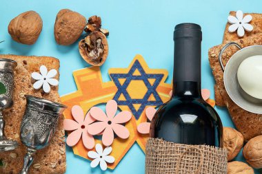 Hamursuz Bayramı kutlaması konsepti. Matzah, kırmızı kaşer cevizi ve mavi arka planda bahar çiçekleri. Geleneksel Yahudi ekmeği. 