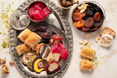 Baklava, halva, rahat lokum, fındık, fıstık, hurma, kuru üzüm, kayısı, kilise. Geleneksel doğu tatlıları, Arap tatlıları, beyaz arka planda Türk tatlıları. Üst görünüm. 