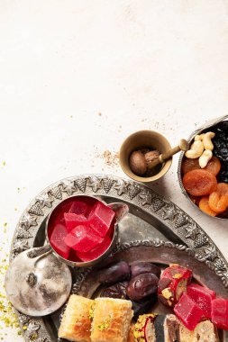 Baklava, halva, rahat lokum, fındık, fıstık, hurma, kuru üzüm, kayısı, kilise. Geleneksel doğu tatlıları, Arap tatlıları, beyaz arka planda Türk tatlıları. Üst Manzara. Boşluğu kopyala.