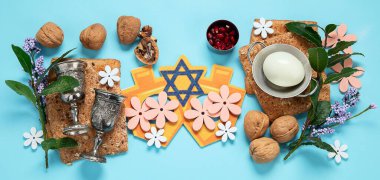 Hamursuz Bayramı kutlaması konsepti. Matzah, kırmızı kaşer cevizi ve mavi arka planda bahar çiçekleri. Geleneksel Yahudi ekmeği. 