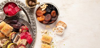 Baklava, halva, rahat lokum, fındık, fıstık, hurma, kuru üzüm, kayısı, kilise. Geleneksel doğu tatlıları, Arap tatlıları, beyaz arka planda Türk tatlıları. Üst Manzara. Kopyalama alanı olan Panorama.