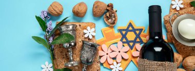 Hamursuz Bayramı kutlaması konsepti. Matzah, kırmızı kaşer cevizi ve mavi arka planda bahar çiçekleri. Geleneksel Yahudi ekmeği. Kopyalama alanı olan Panorama.