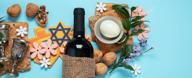 Hamursuz Bayramı kutlaması konsepti. Matzah, kırmızı kaşer cevizi ve mavi arka planda bahar çiçekleri. Geleneksel Yahudi ekmeği. Kopyalama alanı olan Panorama.