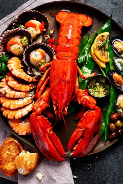 Tabakta büyük kırmızı ıstakoz, karides ve limonlu midye, kıtır sos ve ekmek. Deniz ürünleri konsepti. Üst görünüm.