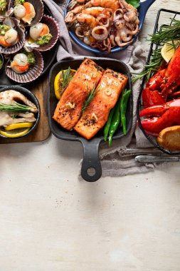 Hafif ahşap arka planda deniz ürünleri tabakları. Üst görünüm, alanı kopyala