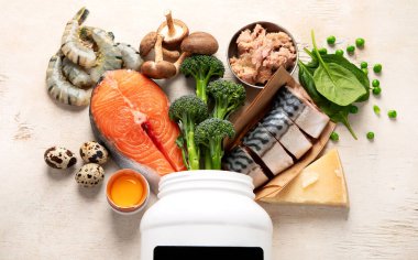 Beyaz zemin üzerinde doğal D vitamini kaynakları (Balık, peynir, yumurta, mantar, karides). Üst görünüm.