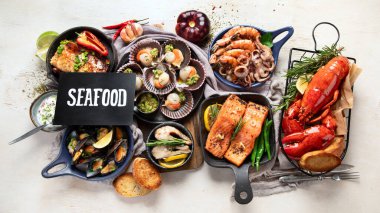 Hafif ahşap arka planda deniz ürünleri tabakları. Üst görünüm