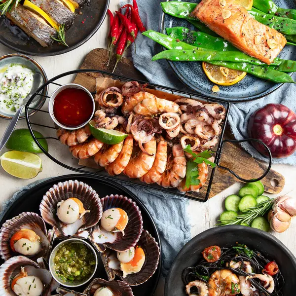 Çeşitli deniz ürünleri ve balık yemekleri. Beyaz arka planda sağlıklı gıda kavramı, üst görünüm.