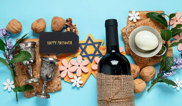 Hamursuz Bayramı kutlaması konsepti. Matzah, kırmızı kaşer cevizi ve mavi arka planda bahar çiçekleri. Geleneksel Yahudi ekmeği. 