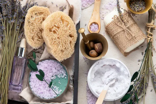 Organik kozmetik konsepti, yağlı cam şişe, pipet ve lavanta çiçekleri, arka planda fırça. Ev yapımı kozmetik ve güzellik konsepti. Üst görünüm.