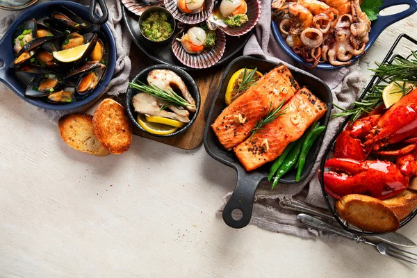 Hafif ahşap arka planda deniz ürünleri tabakları. Üst görünüm, alanı kopyala