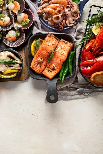 Hafif ahşap arka planda deniz ürünleri tabakları. Üst görünüm, alanı kopyala