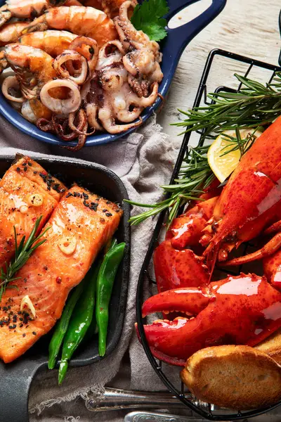 Hafif ahşap arka planda deniz ürünleri tabakları. Üst görünüm