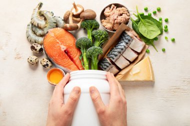 Beyaz zemin üzerinde doğal D vitamini kaynakları (Balık, peynir, yumurta, mantar, karides). Üst görünüm.