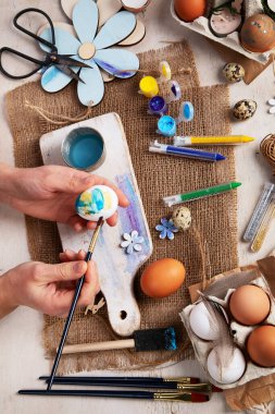 Mutlu Paskalyalar, yumurta boyama. Boyalar, kalemler, beyaz arka planda tatil için yumurta boyama süslemeleri. Üst görünüm.