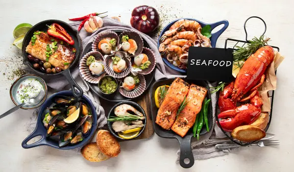 Hafif ahşap arka planda deniz ürünleri tabakları. Üst görünüm