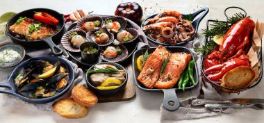 Hafif ahşap arka planda deniz ürünleri tabakları. Pankart