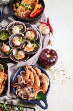 Hafif ahşap arka planda deniz ürünleri tabakları. Üst görünüm, alanı kopyala