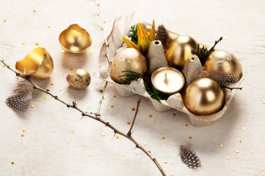 Altın yumurta paskalya konsepti. Hafif arka planda çiçekli Paskalya altın yumurtaları. Mutlu Paskalyalar. Üst görünüm.