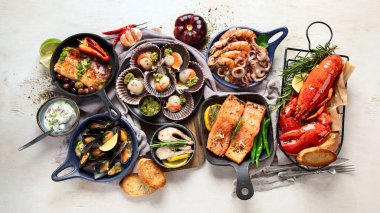 Hafif ahşap arka planda deniz ürünleri tabakları. Üst görünüm