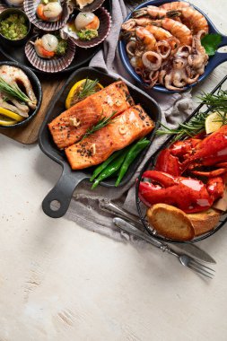 Hafif ahşap arka planda deniz ürünleri tabakları. Üst görünüm, alanı kopyala