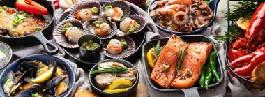 Hafif ahşap arka planda deniz ürünleri tabakları. Pankart