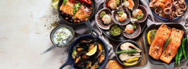 Hafif ahşap arka planda deniz ürünleri tabakları. Üst görünüm, kopyalama alanı, afiş