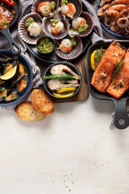 Hafif ahşap arka planda deniz ürünleri tabakları. Üst görünüm, alanı kopyala