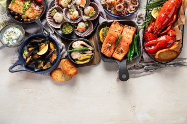 Hafif ahşap arka planda deniz ürünleri tabakları. Üst görünüm, alanı kopyala