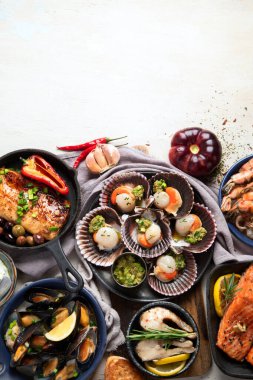 Hafif ahşap arka planda deniz ürünleri tabakları. Üst görünüm, alanı kopyala