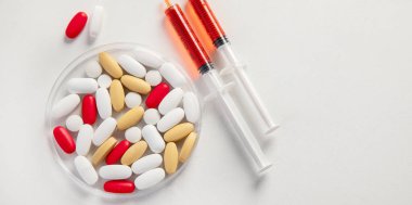 Petri kabında beyaza izole edilmiş çeşitli renkli haplar. Sağlık hizmetleri desteği. Eczane laboratuarı ve ilaç araştırma konsepti. Boşluğu kopyala.