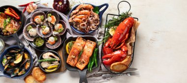 Hafif ahşap arka planda deniz ürünleri tabakları. Üst görünüm, kopyalama alanı, afiş