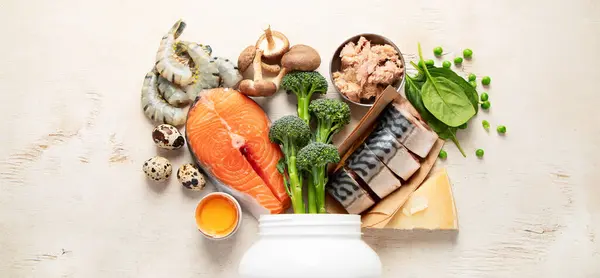 Natural sources of vitamin D (Fish, cheese, eggs, mushrooms, shrimps) on a white background. Top view. Panorama.