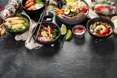 Geleneksel Asya yemek masası. Çin böreği, pirinç, karides, suşi, sebze, arka planda et. Boşluğu kopyala