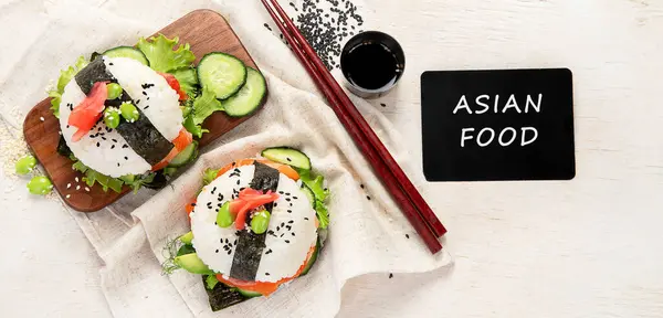 Hybrid modern food. Sushi burger with salmon, white rice, avocado, cucumber. Top view, banner