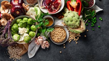 Vejetaryen yemeği. Biber, brokoli, lahana, sarımsak, mantar, koyu arkaplanda nar. Üst görünüm, alanı kopyala