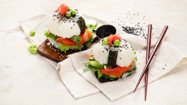 Hybrid modern food. Sushi burger with salmon, white rice, avocado, cucumber. Top view clipart