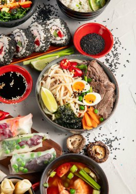 Çeşitli Asya yemekleri. Çin ve Vietnam mutfağı seti. Erişte, pilav, börek, Çin mantısı, börek. Üst görünüm.