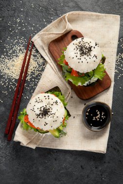 Asya suşi burgeri, soya sosu, arka planda yemek çubuğu. Modaya uygun melez yiyecekler. Süper manzara.