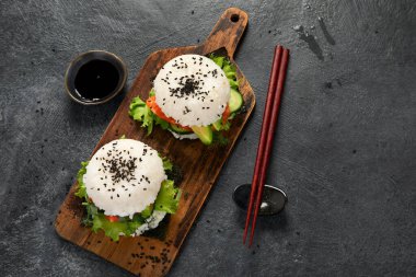 Asya suşi burgeri, soya sosu, arka planda yemek çubuğu. Modaya uygun melez yiyecekler. Süper manzara.