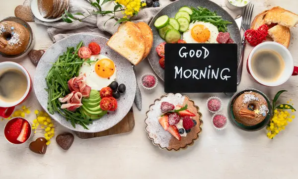 Breakfast served with coffee, fresh bakery, eggs, salad, meat and fruits. Holiday concept. Top view. Copy space.
