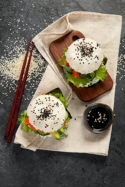 アジアの寿司バーガー 暗い背景にチョップスティック トレンドのハイブリッド食品 トップビュー — ストック写真