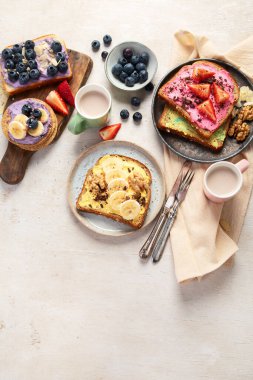 Tatlı tost çeşitleri. Muz, krem peynir, fıstık ezmesi ve çilek, krem peynir ve yaban mersini. Üst Manzara. Boşluğu kopyala.