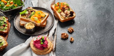 Avokadolu vejetaryen tostu, mantar ve koyu arkaplanda taze salata. Vejetaryen gıda konsepti. Üst görünüm, kopyalama alanı, afiş