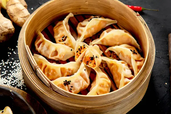 Chinese dumplings, soy sauce, mushrooms on dark background. traditional asian food concept.