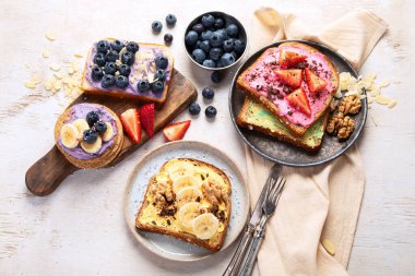 Tatlı tost çeşitleri. Muz, krem peynir, fıstık ezmesi ve çilek, krem peynir ve yaban mersini. Üst görünüm.