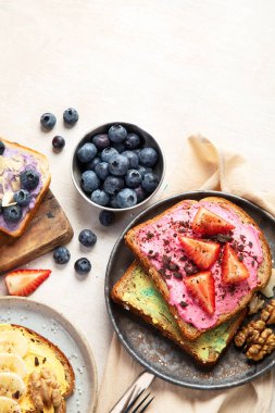 Tatlı tost çeşitleri. Muz, krem peynir, fıstık ezmesi ve çilek, krem peynir ve yaban mersini. Üst Manzara. Boşluğu kopyala.