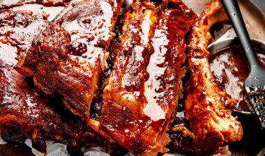 Barbekü soslu bir tabakta servis edilen sıcak ızgara pirzola. Üst görünüm.