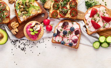 Sebzeli kahvaltı. Kızarmış ekmek, domates, salatalık, turp, avokado. Vejetaryen sağlıklı gıda konsepti. Üst görünüm, alanı kopyala