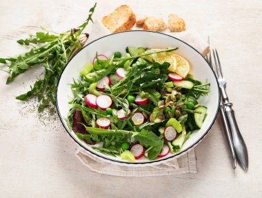 Karahindiba yapraklı bahar vejetaryen salatası, turp, ahşap kaplama salatalık.. 